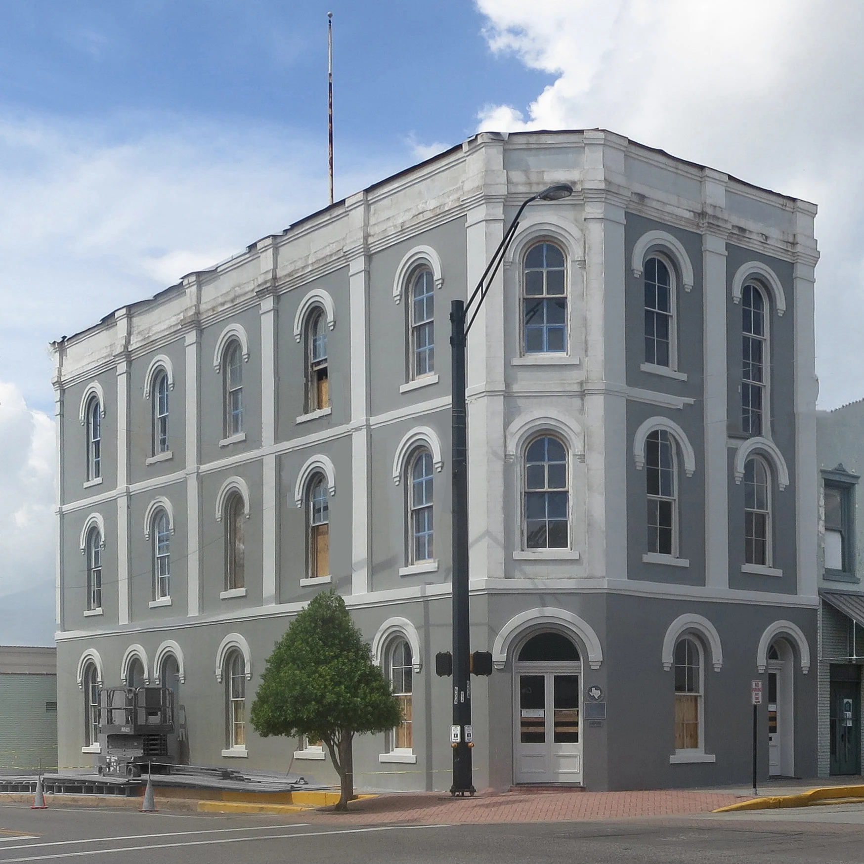 This three-story Italianate building was built to house a bank, law offices and a cotton exchange. The original bank building was built in 1866, and it was rebuilt using local brick. In 1907, renovations were made for the owner’s cotton brokering business, and the building’s classic details were carefully re-crafted. A third floor with a skylight was added to provide the natural light needed to grade cotton. Benjamin H. and Thomas J. Bassett opened this newly-created bank and located their law office in the building soon after its completion. Built with bricks manufactured by the local Wild & Co. Brickyard, the Italianate structure housed the bank until it closed in 1884. An important Brenham landmark, the building features round arches and stucco hood moldings at door and window openings. The third story was added in the early 1900s.
