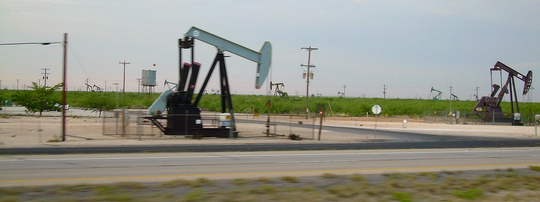 A field of pumpjacks (oil wells) along Interstate 20 near Midland, TX