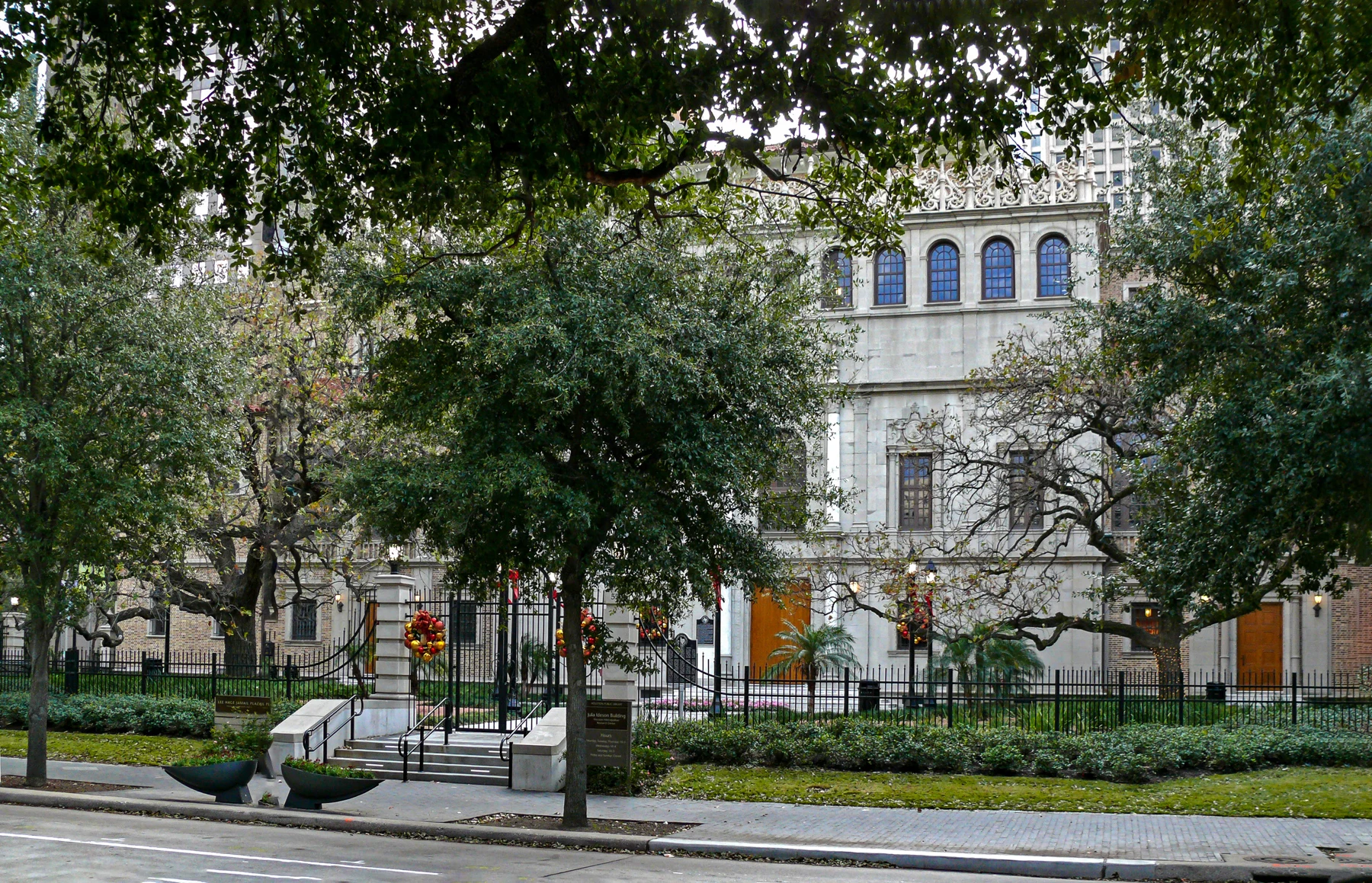 This is the older part of the library built in 1926 and renamed the Julia Ideson Building. There's a larger and more modern structure just west of this building named the Jesse Jones building which is the primary library building today. In the lower center of the picture you can see two markers. The one nearest the fence is the Houston Public Library marker. The one further away on the building is the Julia Ideson Building marker. Early efforts by Houston's Lyceum, local women's organizations and Andrew Carnegie's national foundation led to the 1904 Houston Lyceum and Carnegie Library Building. Julia Bedford Ideson, hired in 1903, was the city's first librarian. Under her direction, the library's collection and services expanded until, by 1920, the 1904 building was too small. The city continued to use the building, known by the 1920s as the Houston Public Library, until 1926, when the new library building opened at this site. Ideson and the library building committee worked throughout the 1920s to formulate a plan and program for the new structure, visiting other U.S. cities and accepting proposals from several noted architects. They chose Ralph Adams Cram and his Boston firm, Cram and Ferguson, for the project. Cram worked with local architects William Ward Watkin and Louis A. Glover, coordinating also with the city's architect, W.A. Dowdy. The Southwestern Construction Company served as the builder. Noted for his design work throughout the Northeast, Cram chose the Spanish