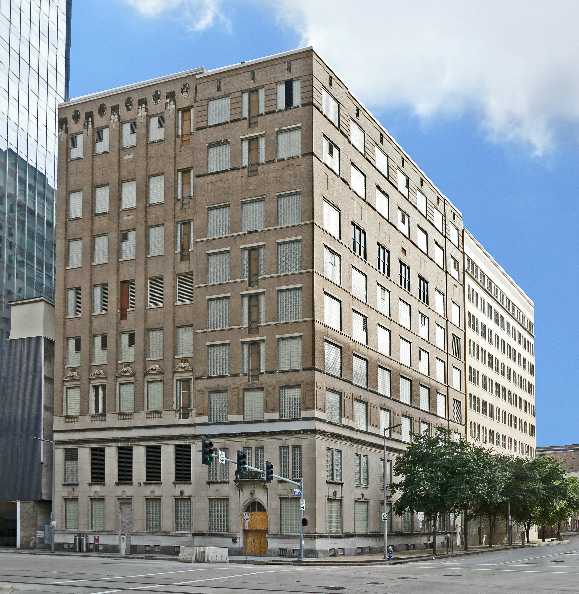 The Southwestern Bell telephone Main Office on Capitol in downtown Houston, Texas, is a functionally-related complex with two abutting buildings: the Commercial Style Main Office at 1121 Capitol Street (originally known as the “Preston Central Office;” 1912, with additions through 1938), and the Late Moderne Style expansion at 1114 Texas Avenue (1950). Occupying opposite sides of the same block, they are internally connected at the rear, an unusual configuration would lead most observers to assume that they are not related in any way, as the 1912 building occupies the southeast corner of the block, while the 1950 building is set between two buildings on the north side of the block. The buildings are stylistically distinct, expressing commercial architectural styles common at their time of construction. The buildings remain on their own separate lots with separate owners, as was the case in 1950. The 1912 building was originally a 7-story Beaux Arts brick skyscraper, which was expanded with a 2-story addition to the west in 1926. By 1938, the original building was topped by a two-story addition with a penthouse, while six floors were added to the west addition. The building has retained its exterior materials, detailing, and massing with the exception of the double hung windows replaced by glass block or louvered vents. The interior, not publicly accessible, has retained is original first floor elevator lobby, granite steps, and chrome handrails. The remainder of the building is largely occupied by switching equipment, cabling, and computers. The 1950 expansion faces north on Texas Avenue and is attached to the 1912 building to the south. The narrow buff brick-clad skyscraper is sixteen stories high, with a mechanical penthouse. Its primary elevation is classically composed of a tripartite base, shaft, and simple cornice, and the fenestration above the first two floors is symmetrical. This elevation is characterized by vertical window bays with red anodized cast aluminum spandrels. Each bay features three windows per floor, separated by plain brick piers. The first two floors are sheathed in windowless white marble slabs over the original limestone panels and granite base